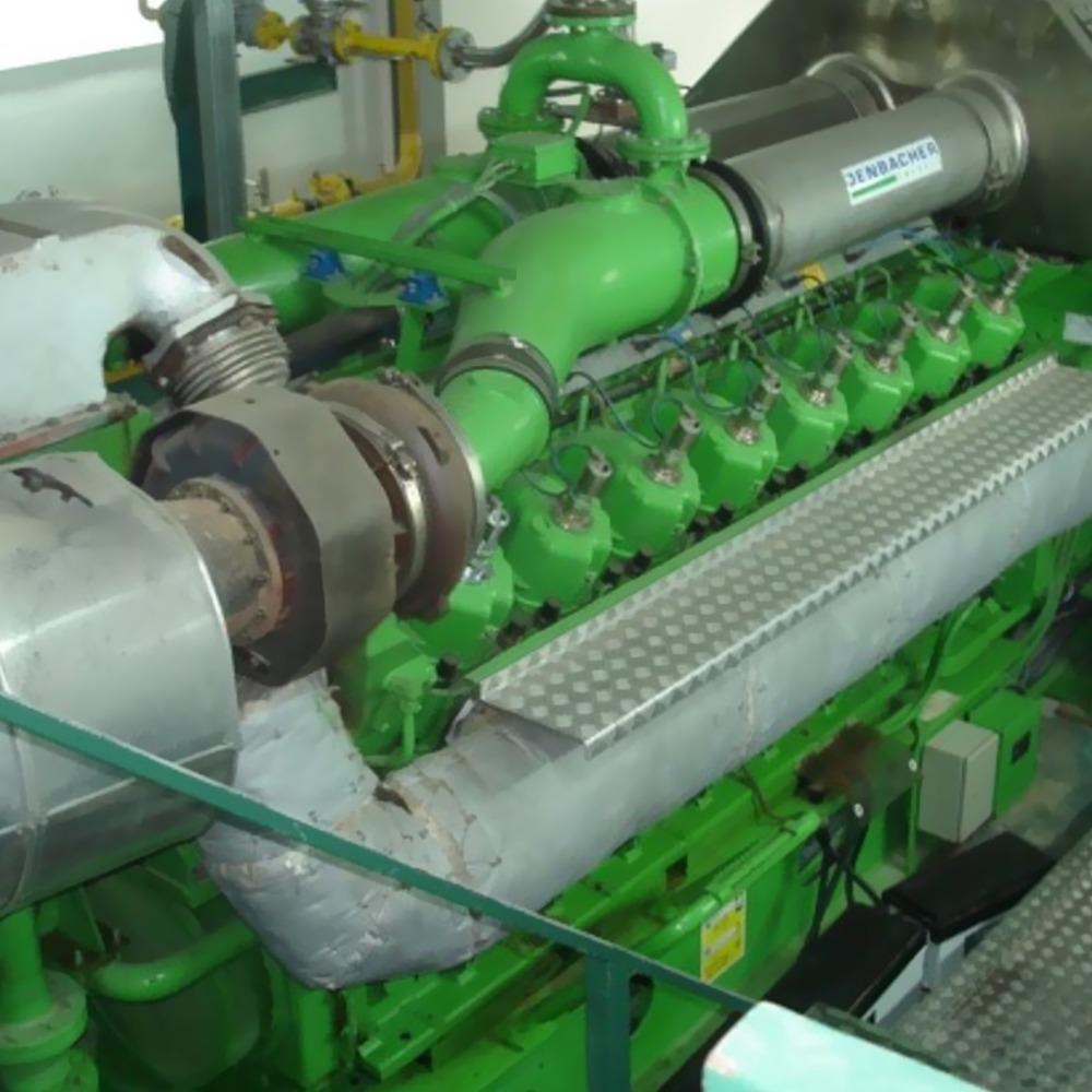 Inspection services provided for a 10 MWe Jenbacher Gas Engine plant in Italy, featuring multiple cylinders, pipes, metal walkways, and visible mechanical components—ideal for facilities needing reliable inspections.