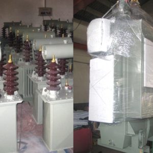 Three new 1300 kVA power transformers with metal casings and ceramic insulators have been delivered, arranged inside the facility; some are unwrapped while one to the right is covered in protective plastic.