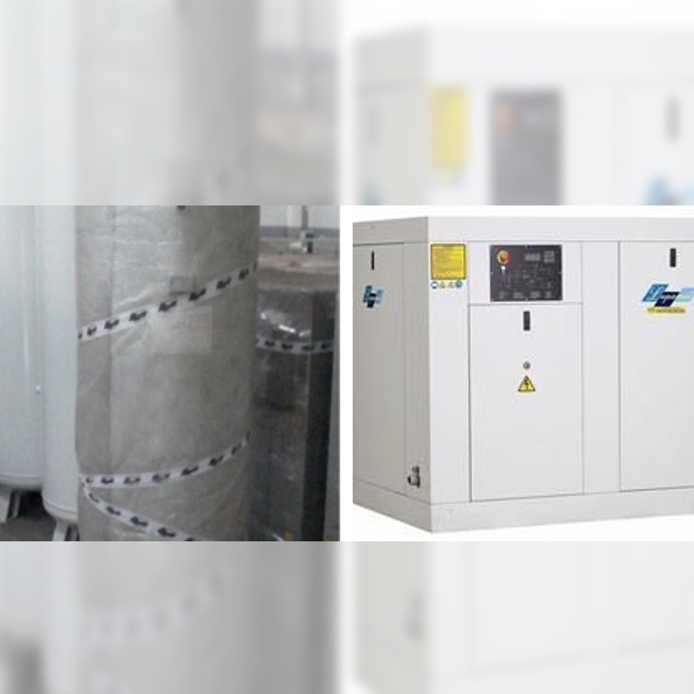A white Screw Type Air Compressor (158 m3/h, 10 bar) with a control panel and warning signs stands beside large cylindrical tanks wrapped in protective material.