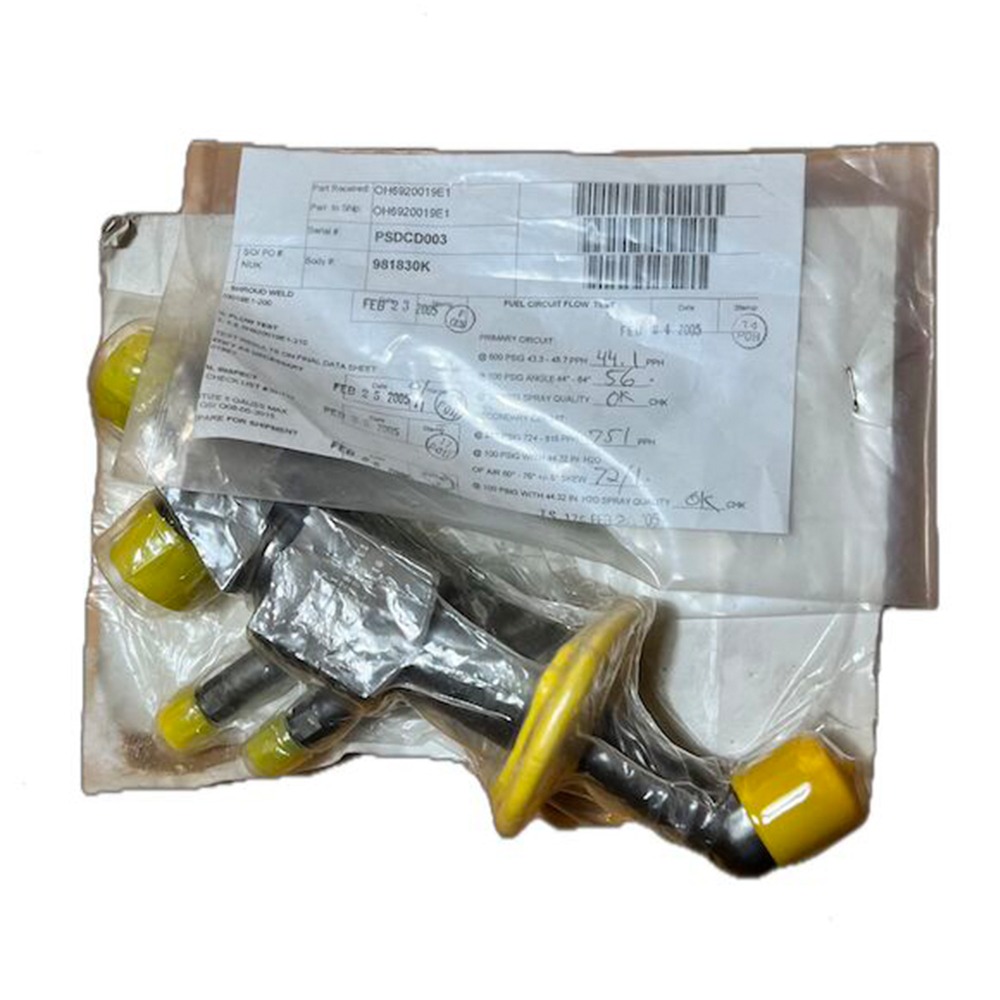 Four overhauled OH Dual Fuel DF Nozzles L47449P01, each with a yellow plastic cap, are shown in clear plastic bags atop a document featuring barcodes and technical information for LM6000 heavy industry applications, all set against a white background.