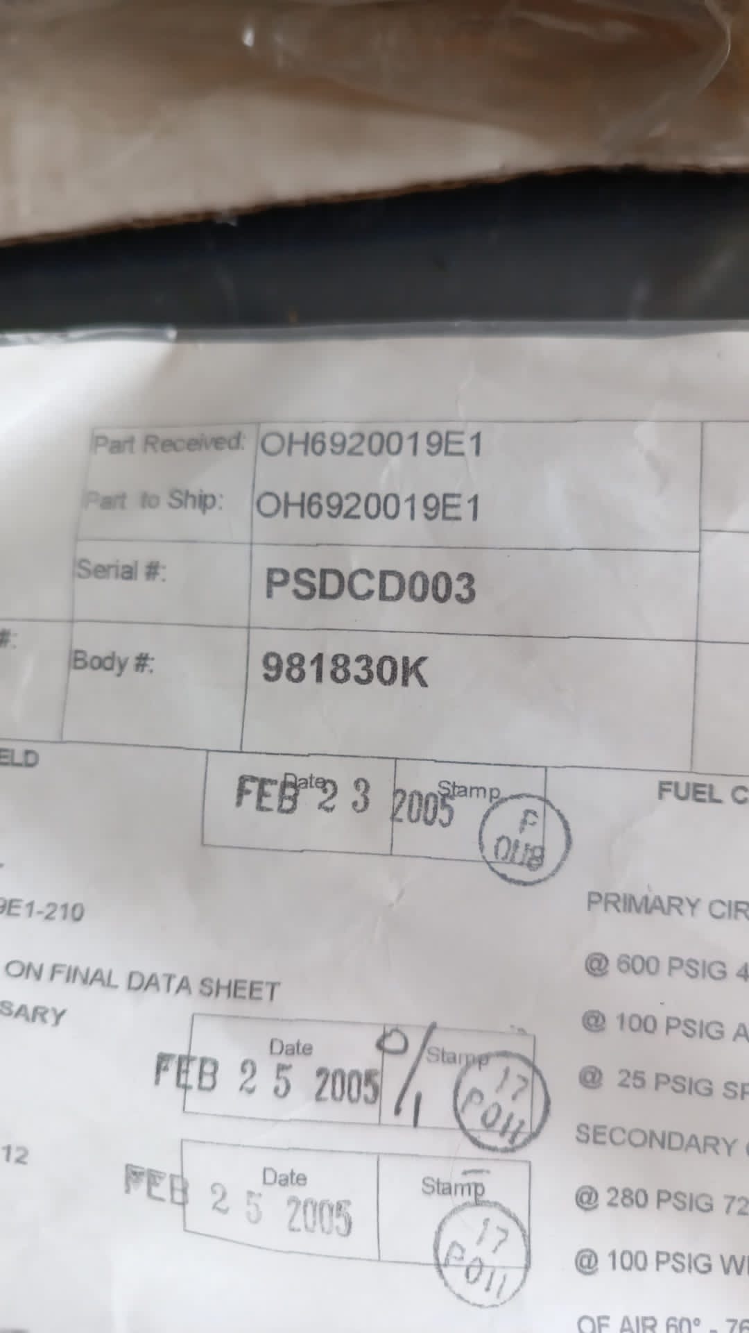 A close-up of a document showing part and serial numbers, a body number, and several date stamps from February 2005. The text is partially creased but remains legible, detailing information related to 4 Overhauled OH Dual Fuel DF Nozzles L47449P01 spare part records.