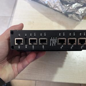 A hand holds a used GE Energy IS420UCSBH4A UCSB Controller Module with labeled Ethernet ports, resting on a light-colored surface.