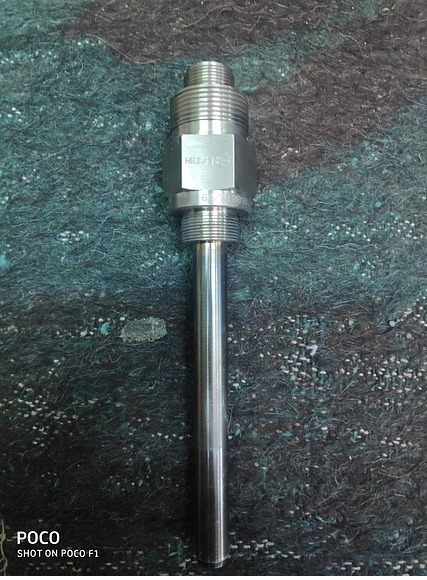 A Siemens Gas Turbine Wanted Igniter IG1-IG6 No. 64/51009011/4 is shown on a textured blue-green surface; its cylindrical body includes a hexagonal middle for easy wrench fitting, ideal for industrial turbine applications.