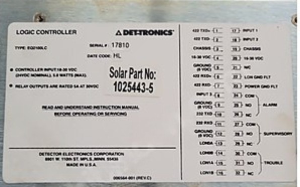 A metal label on the Det-tronics EAGLE QUANTUM LOCAL CONTROL UNIT EQ2100LC LOGIC CONTROLLER lists wiring instructions, terminals, part/serial numbers, and voltage. Bold text Solar Part No: 1025443-5 appears center-right.