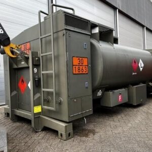 An olive-green Available Refueller Refueler Tank 10000 m3 with hazard signs is parked by gray garage doors, a crane arm on the left. This large tank is ready for heavy-duty fueling operations.