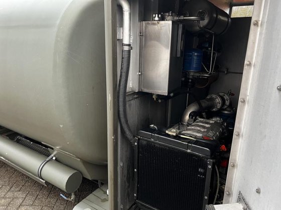 Close-up view of a mechanical compartment on the Available Refueller Refueler Tank 10000 m3, showing metal pipes, a radiator, a blue filter, and engine components partially enclosed within a metal frame.