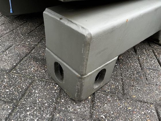 Close-up of the Available Refueller Refueler Tank 10000 m3, a gray rectangular tank with rounded edges and two square holes on the side, resting on interlocking stone pavement.