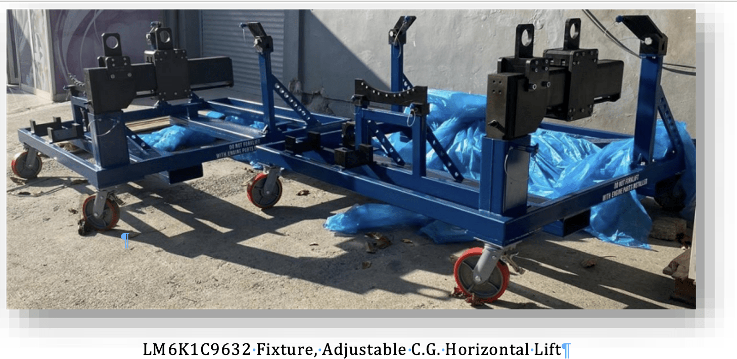 Two blue, wheeled metal fixtures with adjustable arms and locking mechanisms sit outdoors on a concrete surface, partially surrounded by blue plastic sheets. Label: LM6K1C9632-Fixture, Adjustable C.G. Horizontal-Lift.