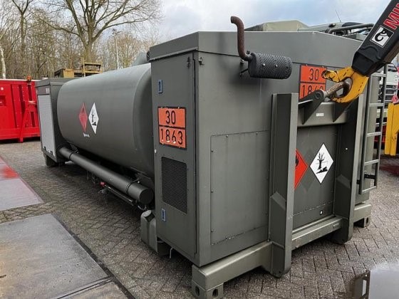 The Available Refueller Refueler Tank 10000 m3, a large gray unit with hazard signs and numbers, is placed outdoors on a paved surface near a tree and red containers.