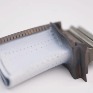 Close-up of a double-edged razor blade with a light blue coating on a white surface, its sharp edge and textured handle echoing the precision of Cfm56 HPT blades PN 2100M96P05 and Cfm56 HPT blades PN 2403M91P06.