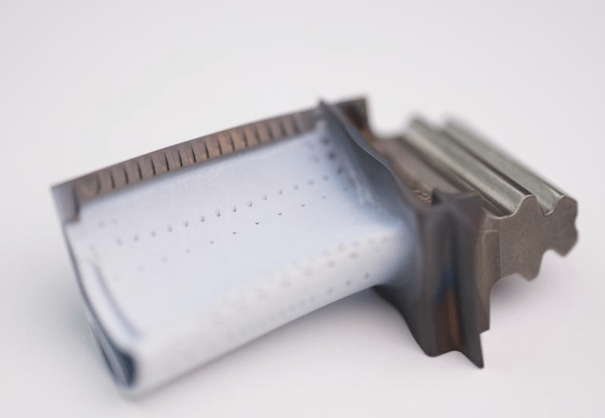 Close-up of a double-edged razor blade with a light blue coating on a white surface, its sharp edge and textured handle echoing the precision of Cfm56 HPT blades PN 2100M96P05 and Cfm56 HPT blades PN 2403M91P06.