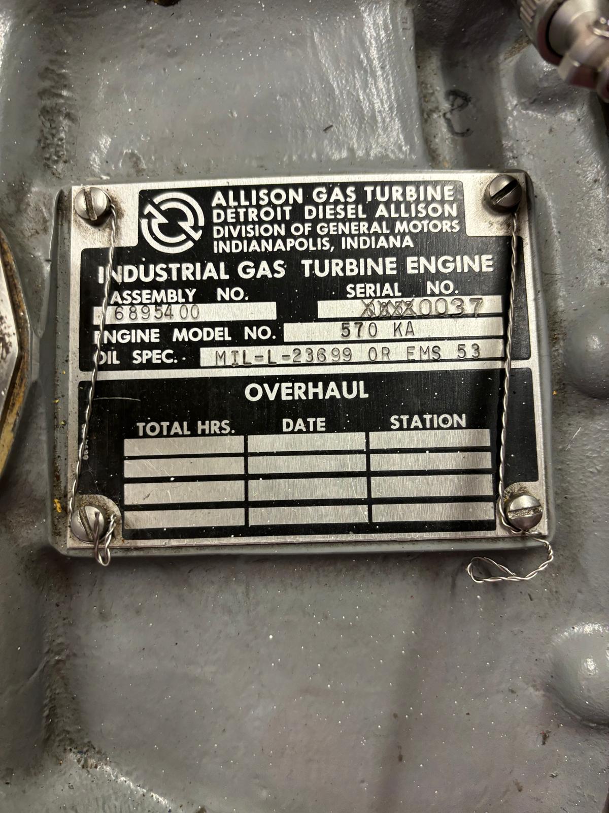 Metal data plate on industrial equipment reads “Allison Gas Turbine Detroit Diesel Allison” and displays engine model, assembly number, oil spec, and overhaul fields, some handwritten. Plate is attached with screws.