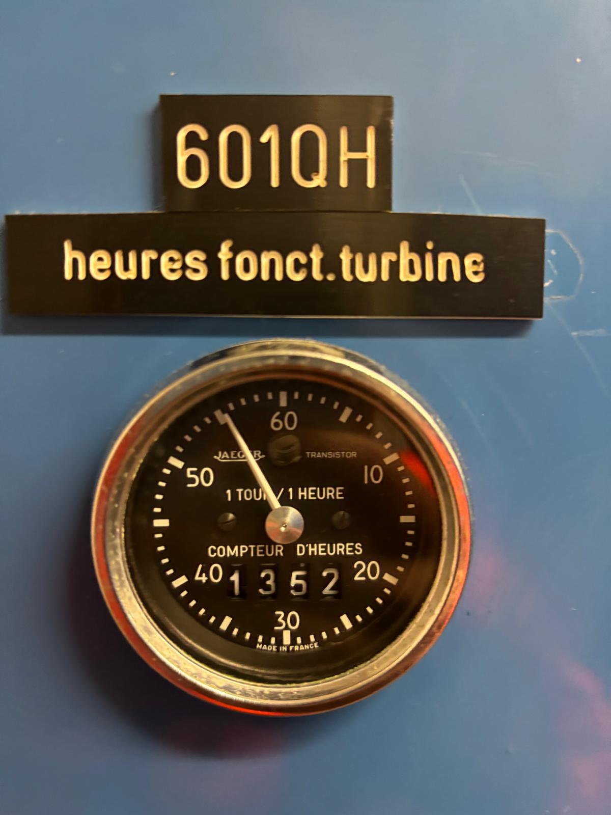 A round hour meter on a blue panel displays 04152 hours. Above it, two labels read 601QH and heures fonct. turbine, indicating turbine operating hours.