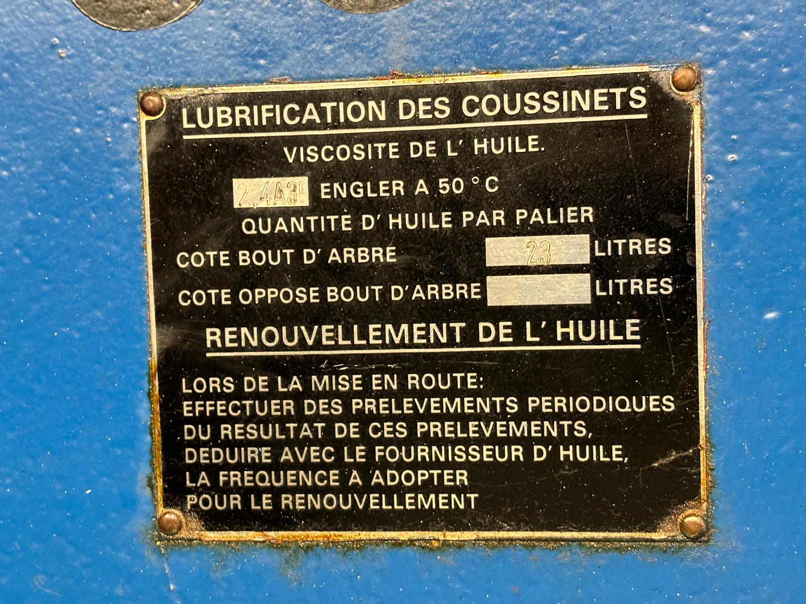 A metal instruction plate in French on a blue surface, detailing oil lubrication for bearings, including viscosity, oil quantity (field values handwritten), and instructions for oil renewal and maintenance procedures.