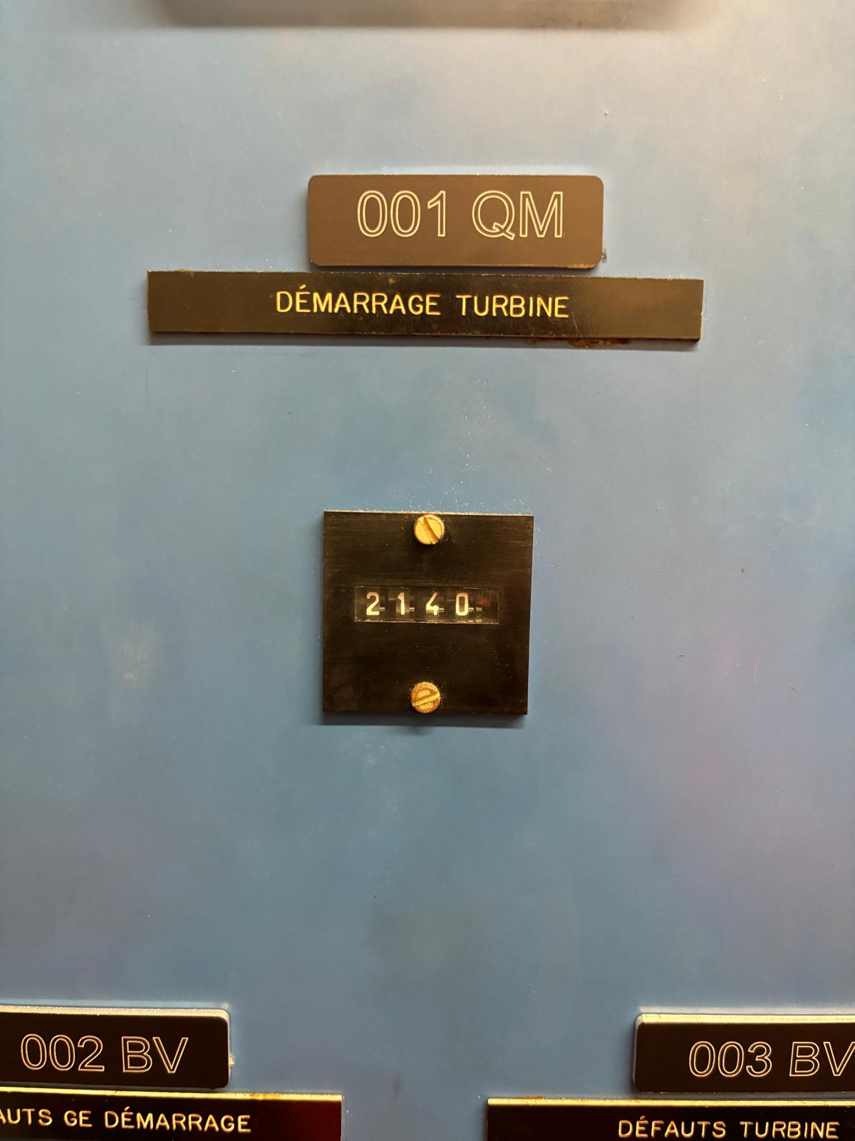 A control panel labeled 001 QM and DÉMARRAGE TURBINE displays the number 2140 in a small window, with additional labels 002 BV and 003 BV partially visible at the bottom.