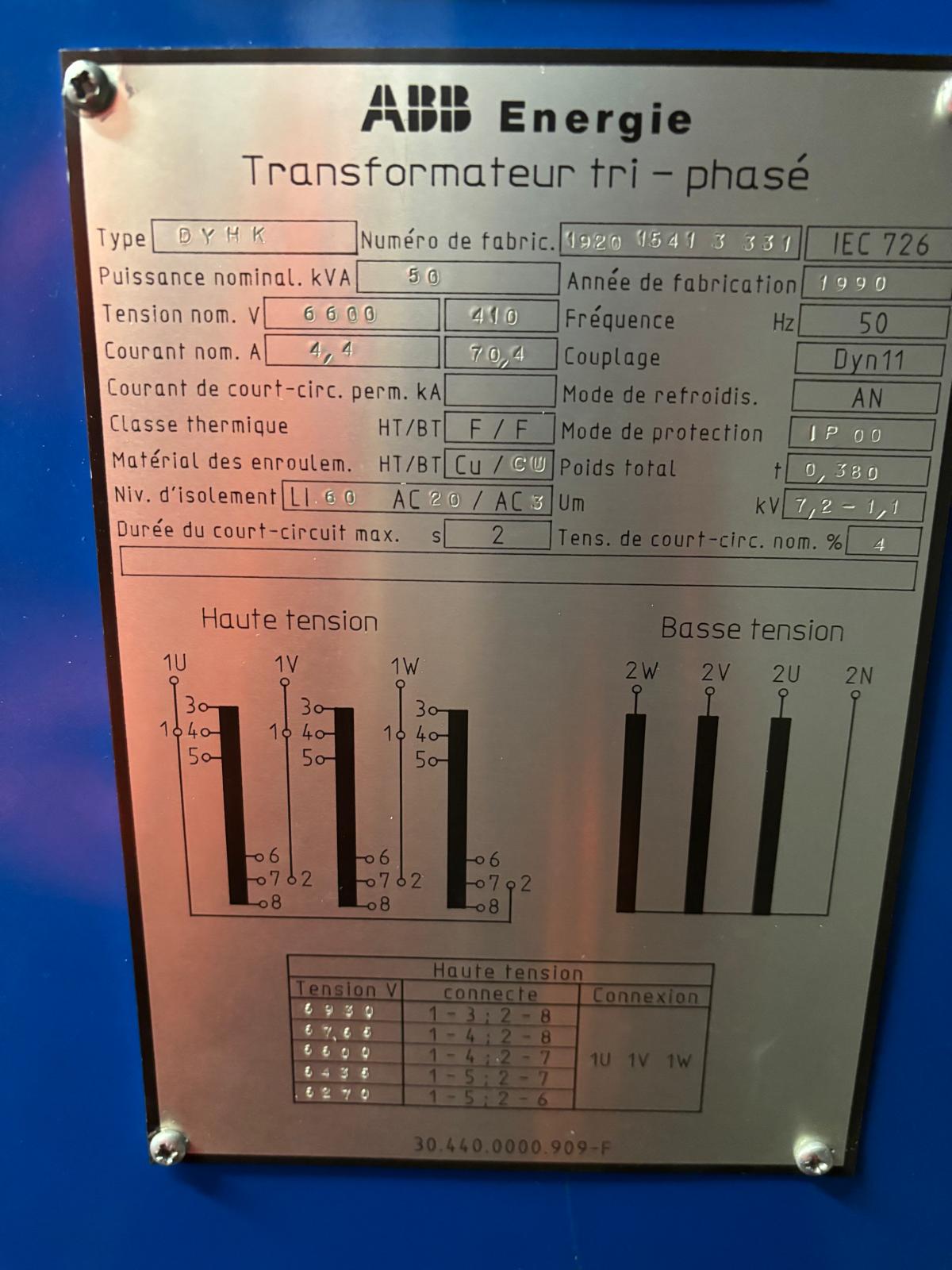 Metallic nameplate for an ABB three-phase transformer showing technical specifications, including voltage, current, frequency, and wiring diagrams for high and low tension connections, with text in French.