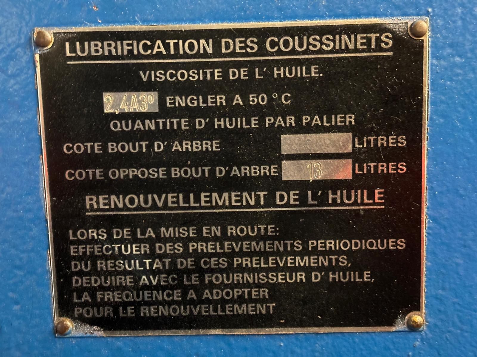 A metal plaque in French showing lubrication instructions for bearings, including oil viscosity, quantities per section, and guidance for oil renewal based on periodic sampling results. The plaque is mounted on a blue surface.