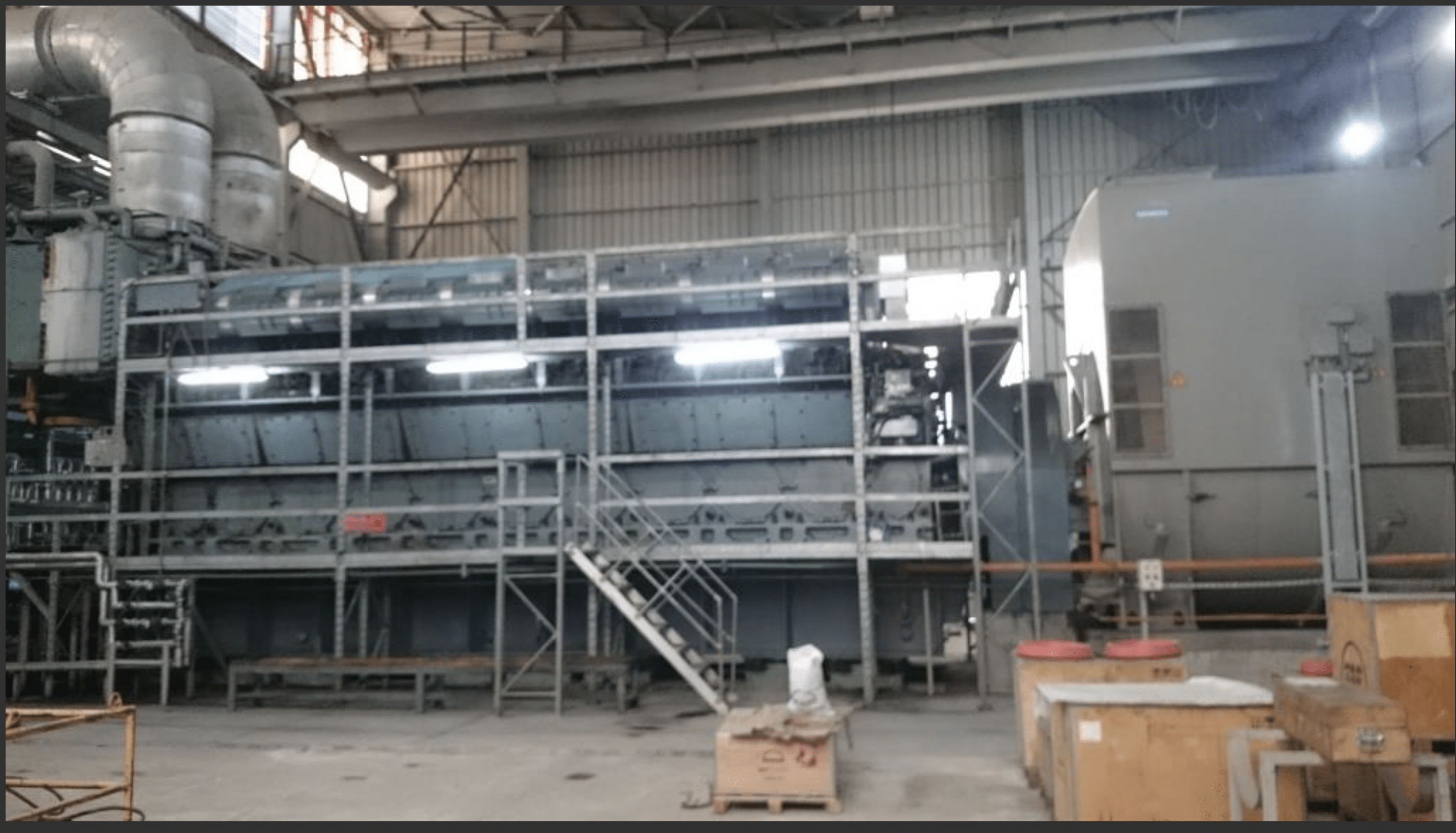 Three used 18V48/60 MAN HFO diesel engines (50 Hz) are installed in a spacious, well-lit power plant with metal frameworks, pipes, stairways, overhead ductwork, and scattered equipment visible throughout the area.