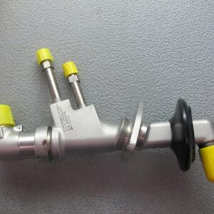 A metal spare part with cylindrical connectors, yellow plastic caps, black rubber boot, and a curved section on a gray surface. Product: SPARE PARTS FOR LM2500 AND LM600 GAS TURBINE ITEMS FOR THE DELIVERY 19062026.