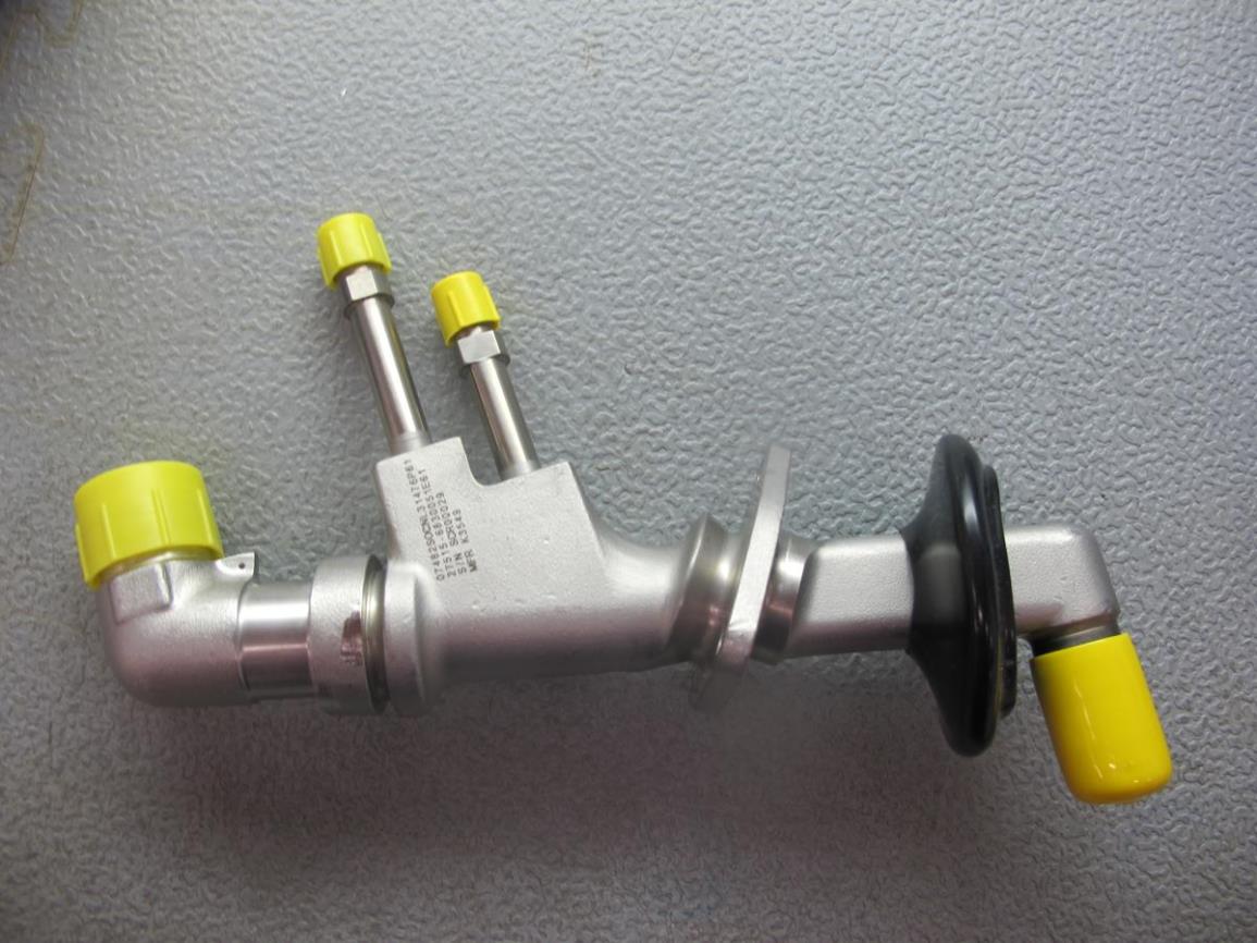 A metal spare part with cylindrical connectors, yellow plastic caps, black rubber boot, and a curved section on a gray surface. Product: SPARE PARTS FOR LM2500 AND LM600 GAS TURBINE ITEMS FOR THE DELIVERY 19062026.